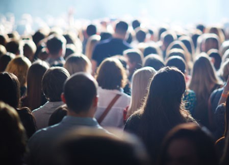 Blurred image of crowd with backs turned to the camera