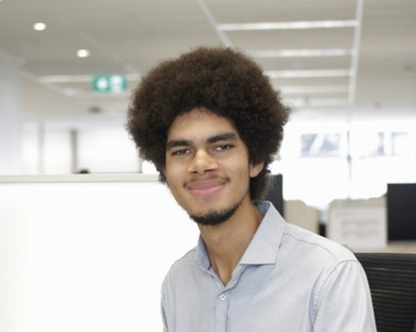 Peter, a graduate program participant, smiling in an office setting.